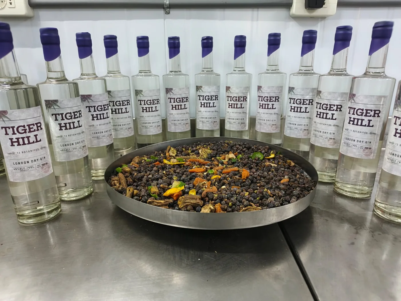 Bottles of Tiger Hill London Dry Gin around a tray of botanicals
